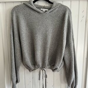 Gray hoodie sweater with adjustable tie at bottom.